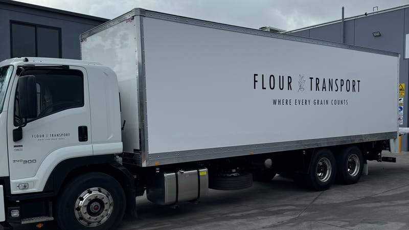 Our white Flour Transport delivery truck, side view, lettered 'Flour Transport – Where every grain counts'